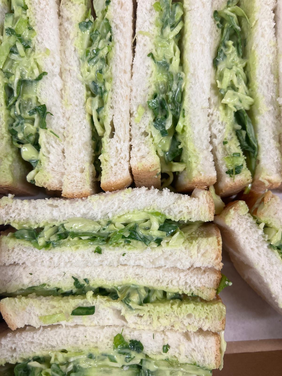 Close up of green goodness sandwiches filled with cabbage, spinach and herbed mayo.