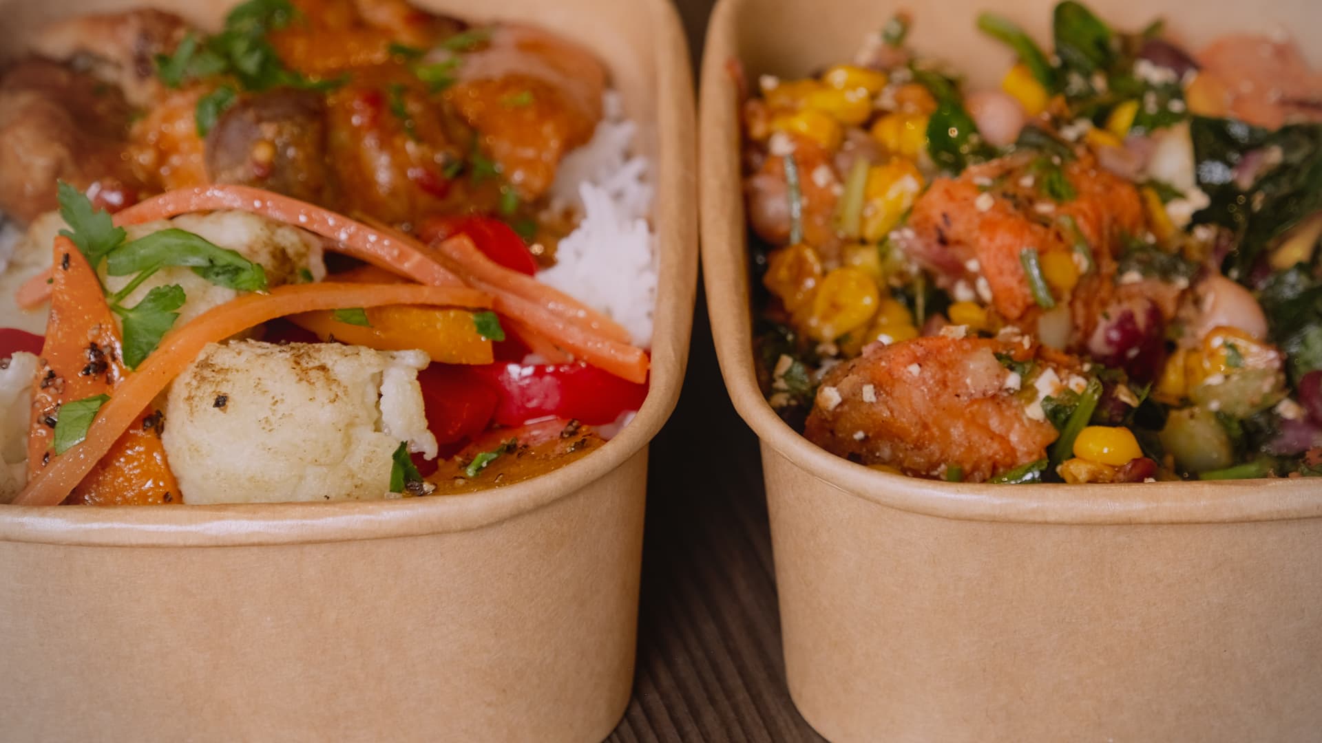 Kraft bowls of rice, curry and fresh salad ready for delivery.